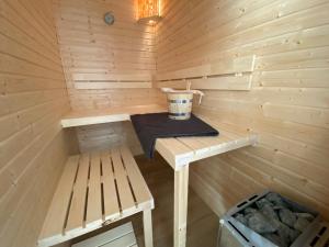 a wooden sauna with a bucket on a table at Heimathafen Damp, Haus 9a in Damp