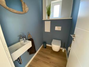 a bathroom with a sink and a toilet at Heimathafen Damp, Haus 9a in Damp +11 photos