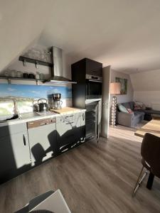una cucina e un soggiorno con divano sullo sfondo di Ferienwohnung Glück a Böhl