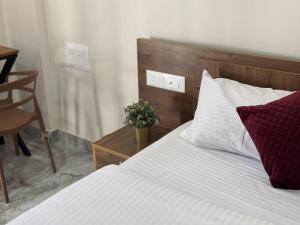 a bedroom with a bed and a table with a plant at Thamarassery INN luxury and budget Rooms in Thamarassery +1 photo