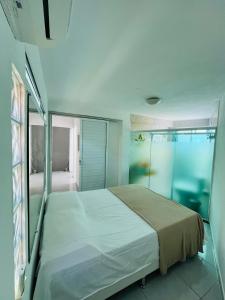 a bedroom with a bed and a glass shower at Casa azul in Maragogi