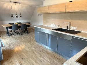 a kitchen with blue cabinets and a table with chairs at Ferienwohnung Becker in Südlohn