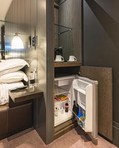 a room with an open refrigerator next to a bed at Dakota Eurocentral in Motherwell