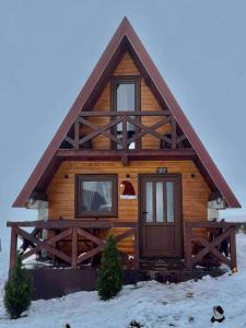 una cabaña de madera en la nieve con un sombrero de Santa en Mountain house Drveni Raj, en Žabljak