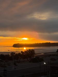 a sunset over a body of water with the sun setting at Mi Ruca in Puerto Madryn