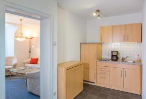 a kitchen with wooden cabinets and a living room at Zentrale Ferienwohnung 51qm im Hotel zur Börse in Hameln