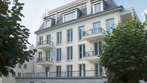 ein weißes Gebäude mit Balkonen an der Seite in der Unterkunft SPA Apartment FIRST Sellin in Ostseebad Sellin