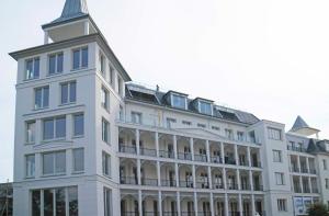 ein weißes Gebäude mit einem Turm darauf in der Unterkunft SPA Apartment FIRST Sellin in Ostseebad Sellin