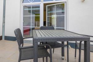 Una mesa y sillas de madera en un patio. en Seewohnung "Rügen", en Gützkow