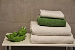 a pile of towels on a table with two green frogs at Villa Grün, Wohnung 10 in Tabarz