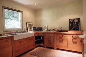 una cucina con armadi in legno, lavandino e finestra di Gartenhaus in Solingen NRW a Solingen