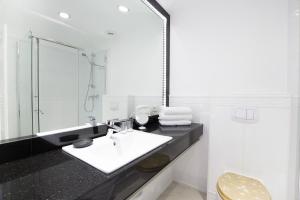 a white bathroom with a sink and a mirror at Windeby 6T in Wenningstedt
