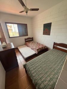 a room with two beds and a ceiling fan at CASA DUPLEX Jardim São Lourenço in Bertioga +35 photos