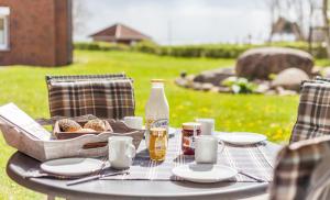 a picnic table with a basket of bread and drinks at Terrassen-Fewo "Ankerplatz" direkt am Ostseestrand inkl Schwimmbad in Kronsgaard