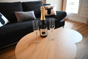 a bottle of champagne and two wine glasses on a table at Gemütliche Maisonette-Wohnung mit Balkon in Todtmoos