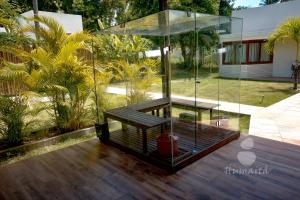 a house with a glass enclosure on a wooden deck at Pousada Humaitá in Japaratinga