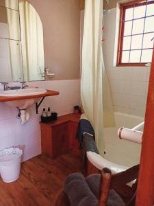 a bathroom with a tub and a sink and a shower at Lavender Cottage in Cape Town +12 photos