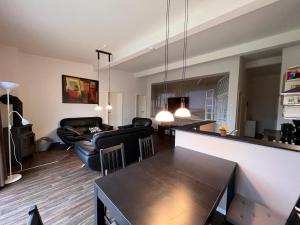 a kitchen and living room with a table and chairs at Leuchtfeuer Fewo "Catrin" in Börgerende-Rethwisch