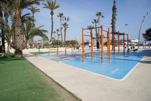 un parco con parco giochi con palme di Casa Elshani en Lo Pagan para hasta 6Pax HHH a San Pedro del Pinatar