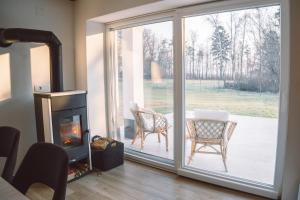 a living room with a sliding glass door with a fireplace at Zelena harmonija in Moravske Toplice +18 photos