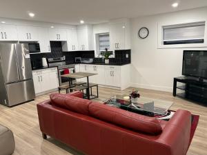 a living room with a red couch and a kitchen at Calm & Cozy Private Suite in Surrey