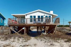 ein Haus an einem Dock am Strand in der Unterkunft Dorsey's Wave On by Meyer Vacation Rentals in Fort Morgan
