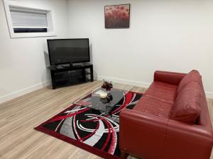 a living room with a couch and a television at Calm & Cozy Private Suite in Surrey