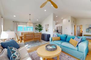 ein Wohnzimmer mit einem blauen Sofa und einem Tisch in der Unterkunft Dorsey's Wave On by Meyer Vacation Rentals in Fort Morgan