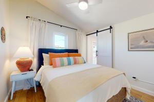 ein Schlafzimmer mit einem Bett und einer Lampe auf einem Tisch in der Unterkunft Dorsey's Wave On by Meyer Vacation Rentals in Fort Morgan