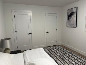 a white bedroom with two closets and a bed at Calm & Cozy Private Suite in Surrey