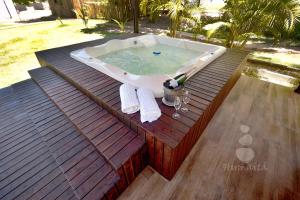 a bath tub sitting on top of a wooden deck at Pousada Humaitá in Japaratinga