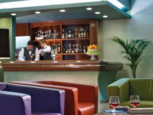 un bar in un ristorante con due uomini che stanno al bancone di Hotel Terme Marco Polo a Montegrotto Terme