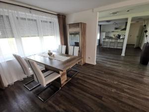 Un comedor con mesa y sillas de madera. en FeWo Urbaniak Waddens, en Butjadingen