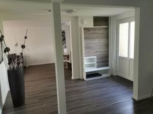 sala de estar con un jarrón en el suelo y TV en FeWo Urbaniak Waddens, en Butjadingen