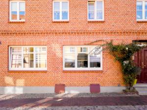 a red brick building with windows and a tree at Ziegenmarktidylle im zweitältesten Haus von Röbel in Röbel