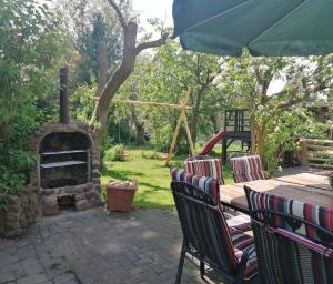 a table and chairs with a fireplace in a yard at Knoofs in Schwirzheim