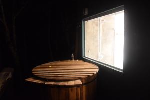 a wooden tub with a candle in front of a window at Refugio Marincek - Gonçalves - MG in Gonçalves