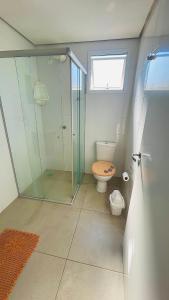 a bathroom with a toilet and a glass shower at Ap de 2 quartos com AR, wifi e garagem - Bairro tranquilo in Santo Ângelo +6 photos