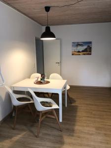 a dining room with a white table and chairs at FeWo "Prerow" in Prerow