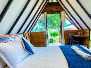 莱瓦镇Glamping Chalet Deluxe cerca al centro de Villa de Leyva - By Serena Morena的一间带床和大窗户的卧室