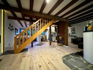 a living room with a wooden staircase in a house at Blockhaus Ourtal in Winterspelt