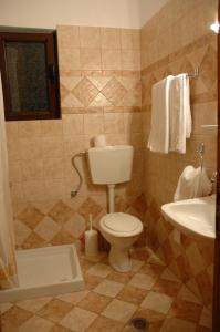 La salle de bains est pourvue de toilettes et d'un lavabo. dans l'établissement Aroanios Hotel, à Kleitoria