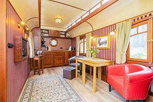 a train room with a red chair and a table at Zigappo Pullman in Lychen +2 photos