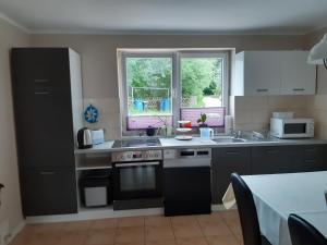 a kitchen with a stove and a sink and a window at Ferienwohnung in Gresenhorst