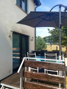 a table with an umbrella and chairs on a deck at Ferienwohnung in Gresenhorst