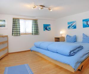 1 dormitorio con 1 cama grande con sábanas azules en Haus Leopold, en Zermatt