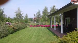 a yard with pink flowers and a house at Haus Seeblick Nr 48 in Geeste