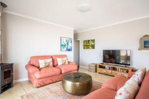 a living room with two couches and a tv at Capri House in Cape Town