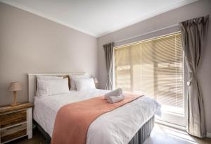 a bedroom with a bed with a stuffed animal on it at Capri House in Cape Town