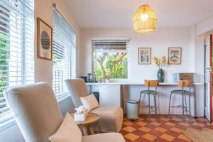 ein Wohnzimmer mit einer Küche mit Stühlen und einer Theke in der Unterkunft St James Garden Cottage in St James + 15 Fotos